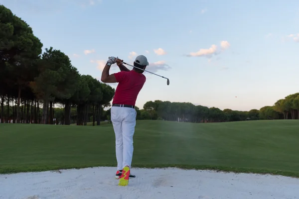 Golfista batendo um bunker de areia tiro no pôr do sol — Fotografia de Stock