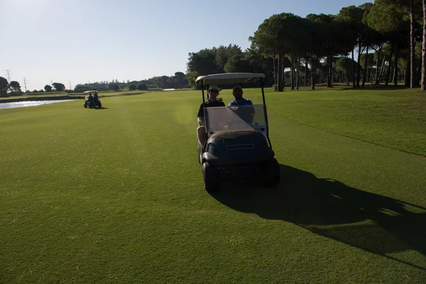 Jugadores de golf que conducen carro en curso —  Fotos de Stock