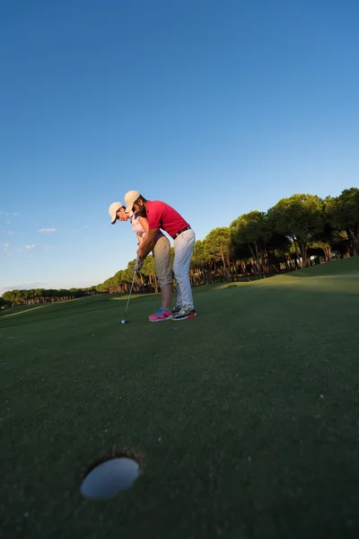 Male golf instructor teaching female golf player — Stock Photo, Image