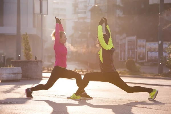 Couple warming up before jogging — Stock Photo, Image