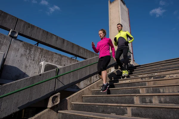 Jong koppel joggen op stappen — Stockfoto