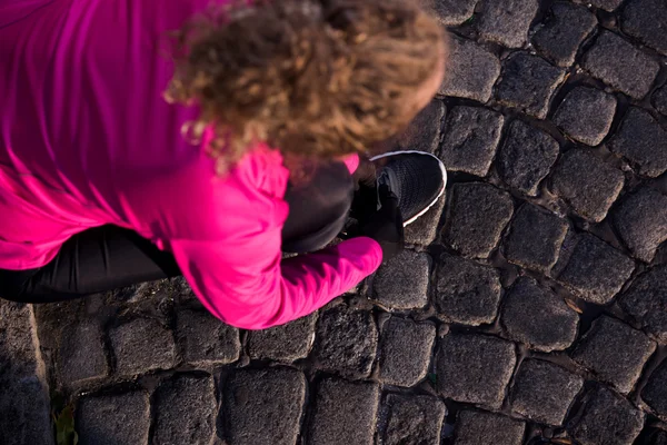 Vrouw die zich uitstrekt voordat ochtend joggen — Stockfoto