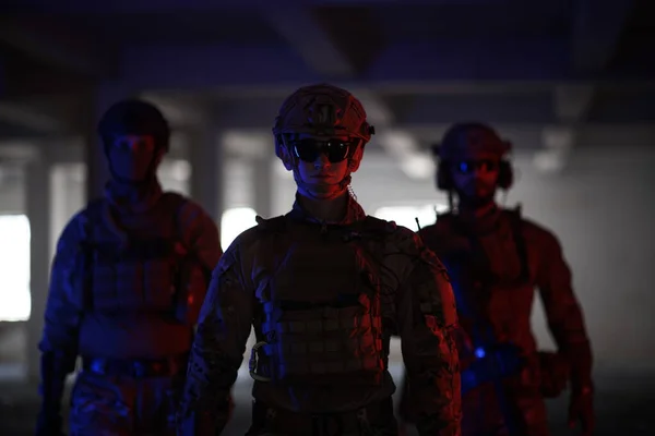Équipe de soldats marchant dans un environnement urbain lumière colorée — Photo