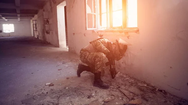 Soldado en acción cerca de la ventana cambiante revista y ponerse a cubierto — Foto de Stock