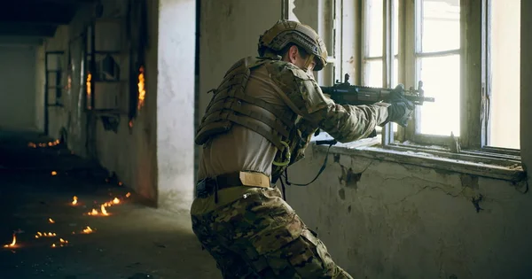 Soldado em ação perto de janela mudando revista e se abrigar — Fotografia de Stock