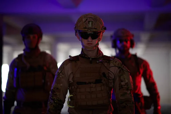 Équipe de soldats marchant dans un environnement urbain lumière colorée — Photo