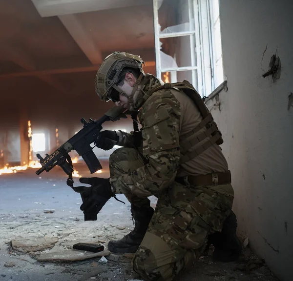 Soldier in action near window changing magazine and take cover — Stock Photo, Image