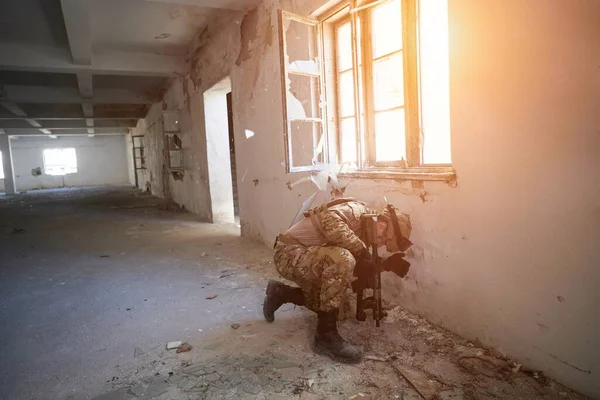 Soldado em ação perto de janela mudando revista e se abrigar — Fotografia de Stock