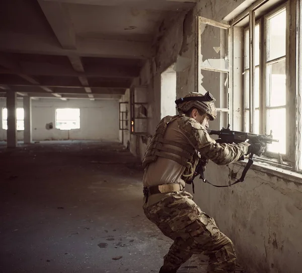 Soldat en action près de fenêtre changeant de magazine et prendre refuge — Photo