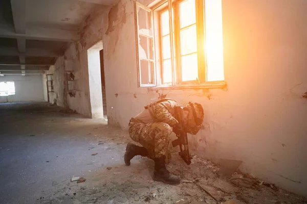 Soldado em ação perto de janela mudando revista e se abrigar — Fotografia de Stock