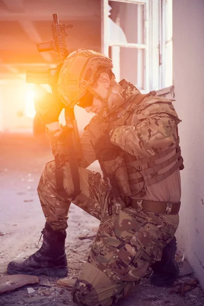 Soldier in action near window changing magazine and take cover — Stock Photo, Image