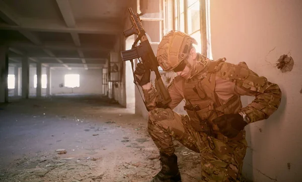 soldier in action near window changing magazine and take cover