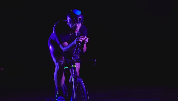 Τρίαθλο Αθλητής Ποδηλασία Γρήγορη Ιππασία Επαγγελματικό Αγωνιστικό Ποδήλατο Νύχτα Νέον — Φωτογραφία Αρχείου