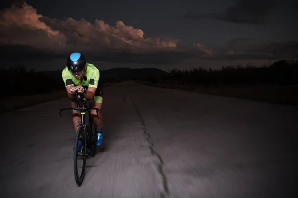 Triatlo atleta andar de bicicleta rápido à noite — Fotografia de Stock