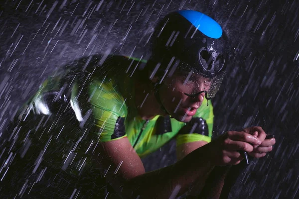 Triatlo atleta andar de bicicleta rápido na noite chuvosa — Fotografia de Stock