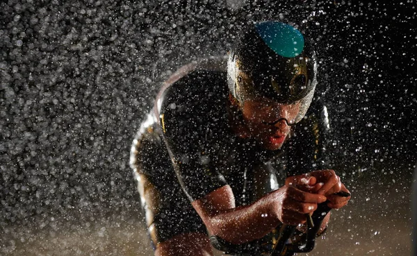 Triatlon atléta lovaglás kerékpár gyors esős éjszakán — Stock Fotó
