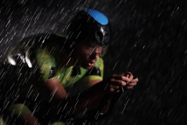 雨夜骑自行车快的三项全能运动员 — 图库照片