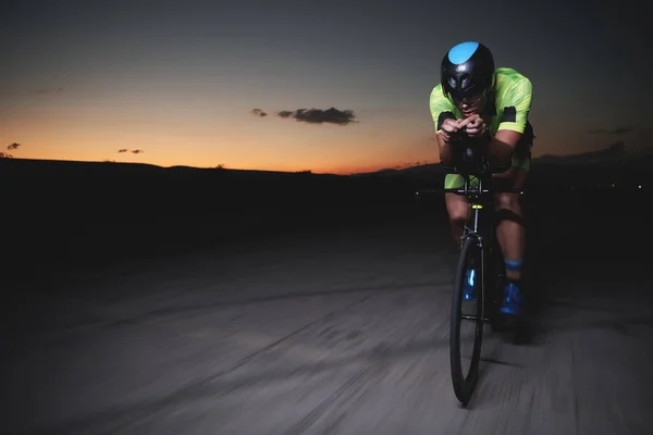 Triatlon atleet rijden fiets snel 's nachts — Stockfoto