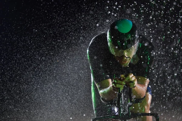 Triathlon idrottare rida cykel snabbt på regnig natt — Stockfoto