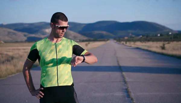 Atleta de triatlón descansando y estableciendo smartwatch — Foto de Stock