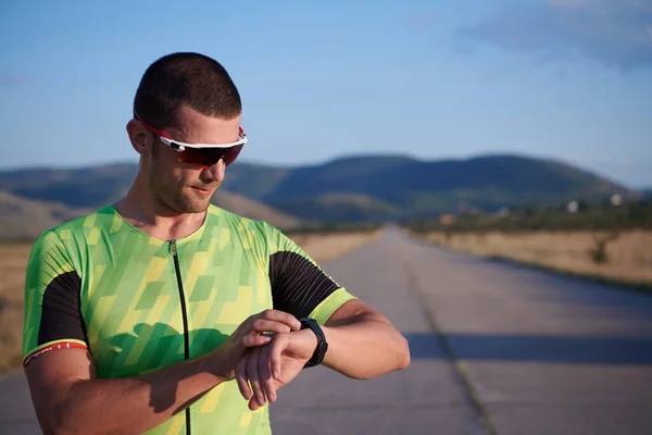 Triathlon sportowiec odpoczynku i ustawienie smartwatch — Zdjęcie stockowe