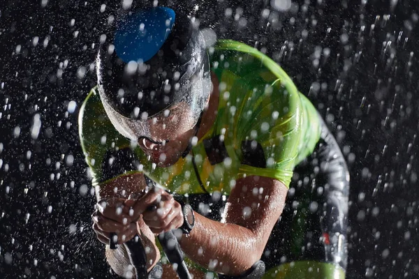 Triathlon athlete riding bike fast on rainy night — Stock Photo, Image
