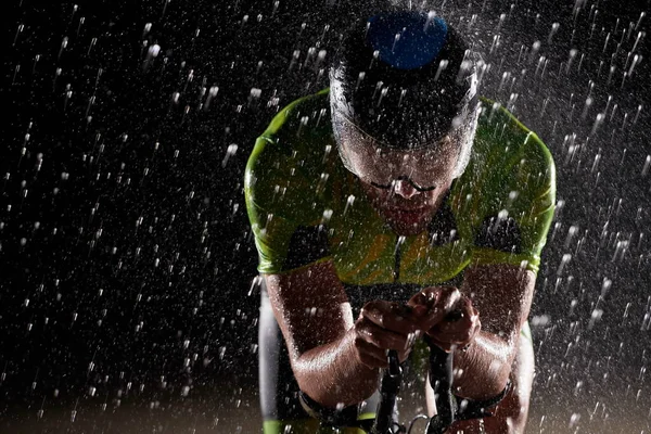 Τρίαθλο αθλητής ιππασίας ποδήλατο γρήγορα σε βροχερή νύχτα — Φωτογραφία Αρχείου