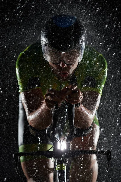 Triatlón atleta montar bicicleta rápido en la noche lluviosa —  Fotos de Stock