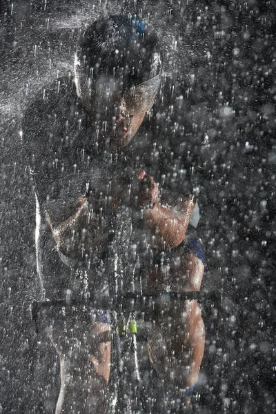 雨夜骑自行车快的三项全能运动员 — 图库照片