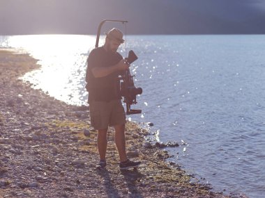 kameraman triatlon yüzme sporcusunun aksiyon fotoğrafını çekiyor