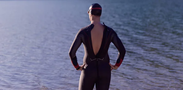 Autentyczny triathlon sportowiec przygotowuje się do treningu pływackiego na jeziorze — Zdjęcie stockowe