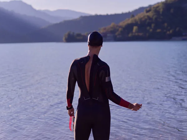 Athlète de triathlon authentique se prépare pour l'entraînement de natation sur le lac — Photo