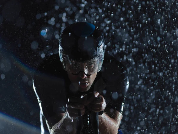 Triatlon atleet paardrijden fiets op regenachtige nacht — Stockfoto