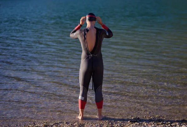 Auténtico atleta triatlón preparándose para el entrenamiento de natación en el lago — Foto de Stock