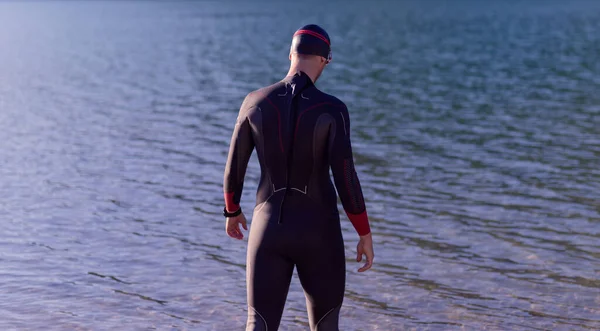 Authentieke triatlonatleet die zich klaarmaakt voor zwemtraining aan het meer — Stockfoto