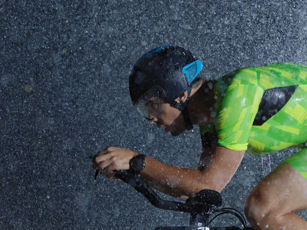 Triathlon idrottare ridning cykel på regnig natt — Stockfoto