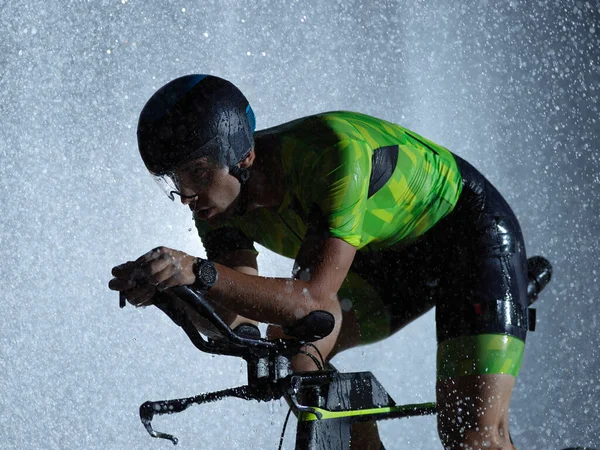 Atleta di triathlon in bicicletta nella notte di pioggia — Foto Stock