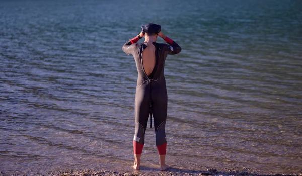 Autentisk triathlon atlet bliver klar til svømning træning på søen - Stock-foto