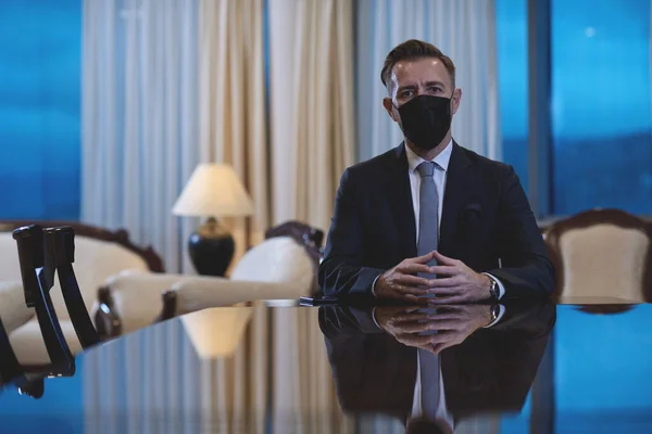 명품 사무실에서 얼굴을 보호하는 마스크를 쓰고 있는 사업가 — 스톡 사진