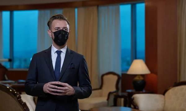 Uomo d'affari che indossa maschera protettiva in ufficio — Foto Stock