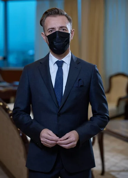 Uomo d'affari che indossa maschera protettiva in ufficio — Foto Stock