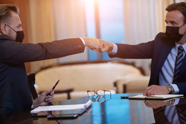 business people wearing face mask on meeting and handshake