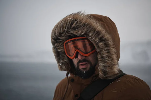 Hombre en invierno en clima tormentoso usando abrigo de piel caliente —  Fotos de Stock