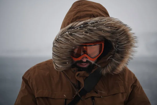 Homme à l'hiver par temps orageux portant une veste de fourrure chaude — Photo