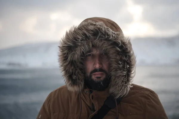 Hombre en invierno en clima tormentoso usando abrigo de piel caliente — Foto de Stock