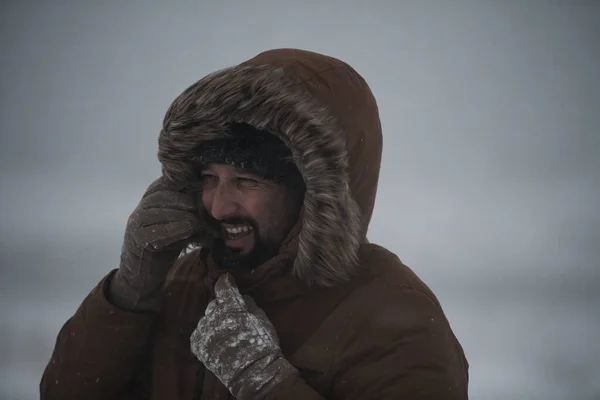 Hombre en invierno en clima tormentoso usando abrigo de piel caliente —  Fotos de Stock