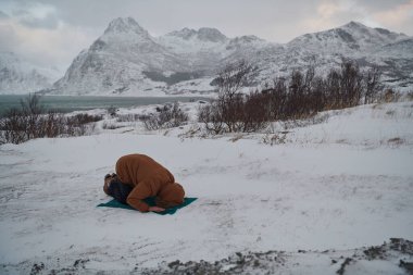 Müslüman gezgin soğuk kış gününde dua ediyor.