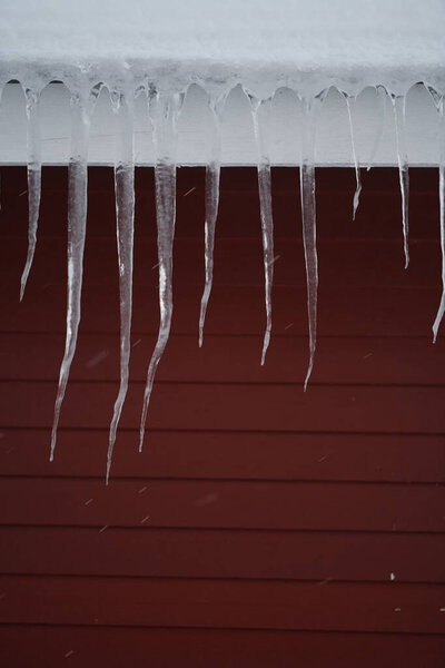 icicles on the roof of a red house in Norway