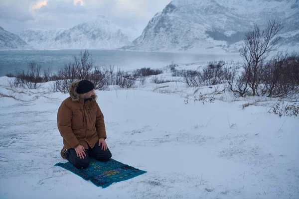 Muslim traveler praying in cold snowy winter day — Stock Photo, Image