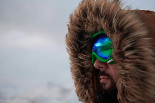 Uomo in inverno in tempo tempestoso indossa giacca di pelliccia calda — Foto Stock